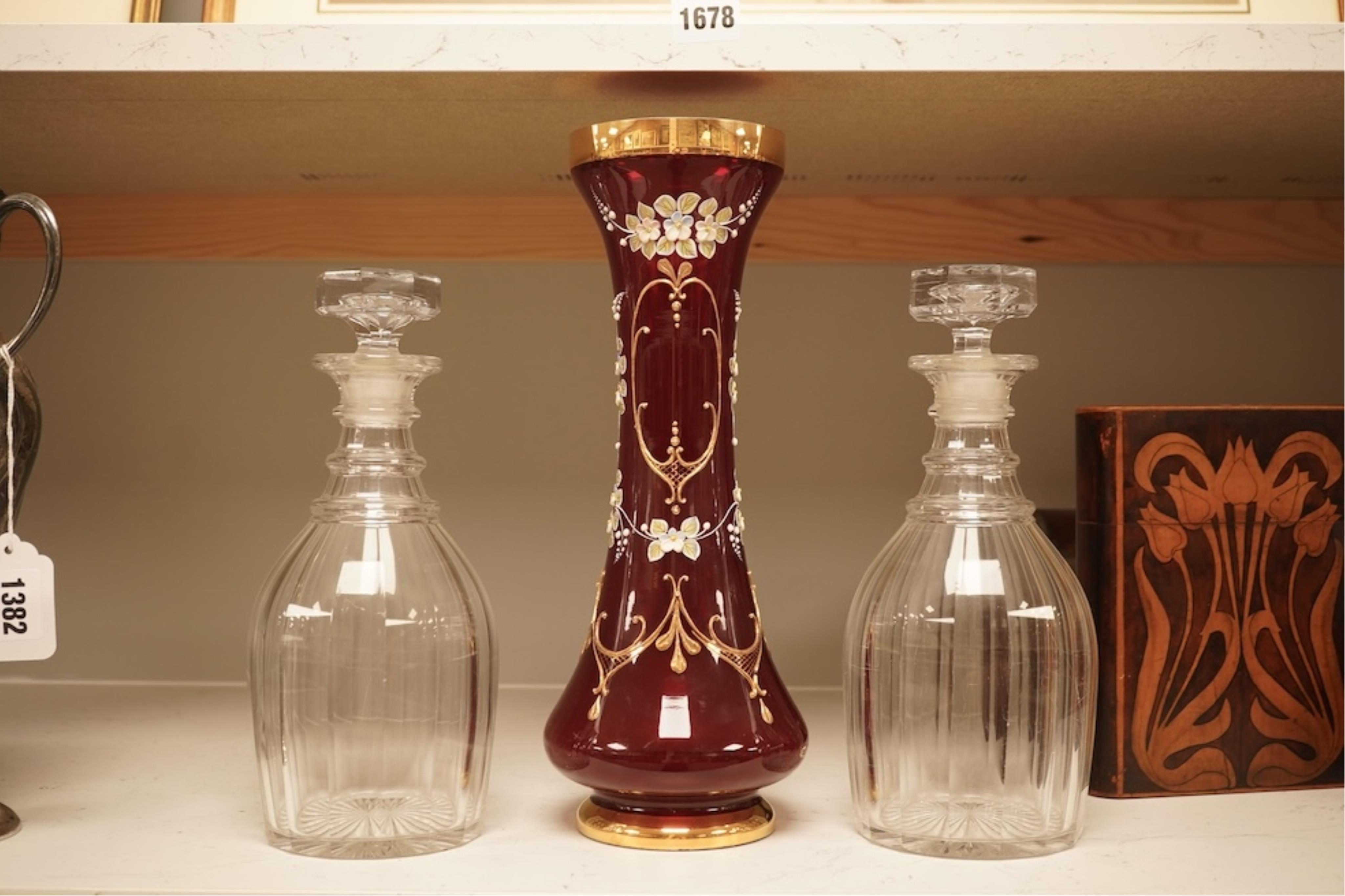 A pair of Victorian glass decanters, later stoppers, and an enamelled ruby glass vase, latter 32cm high
